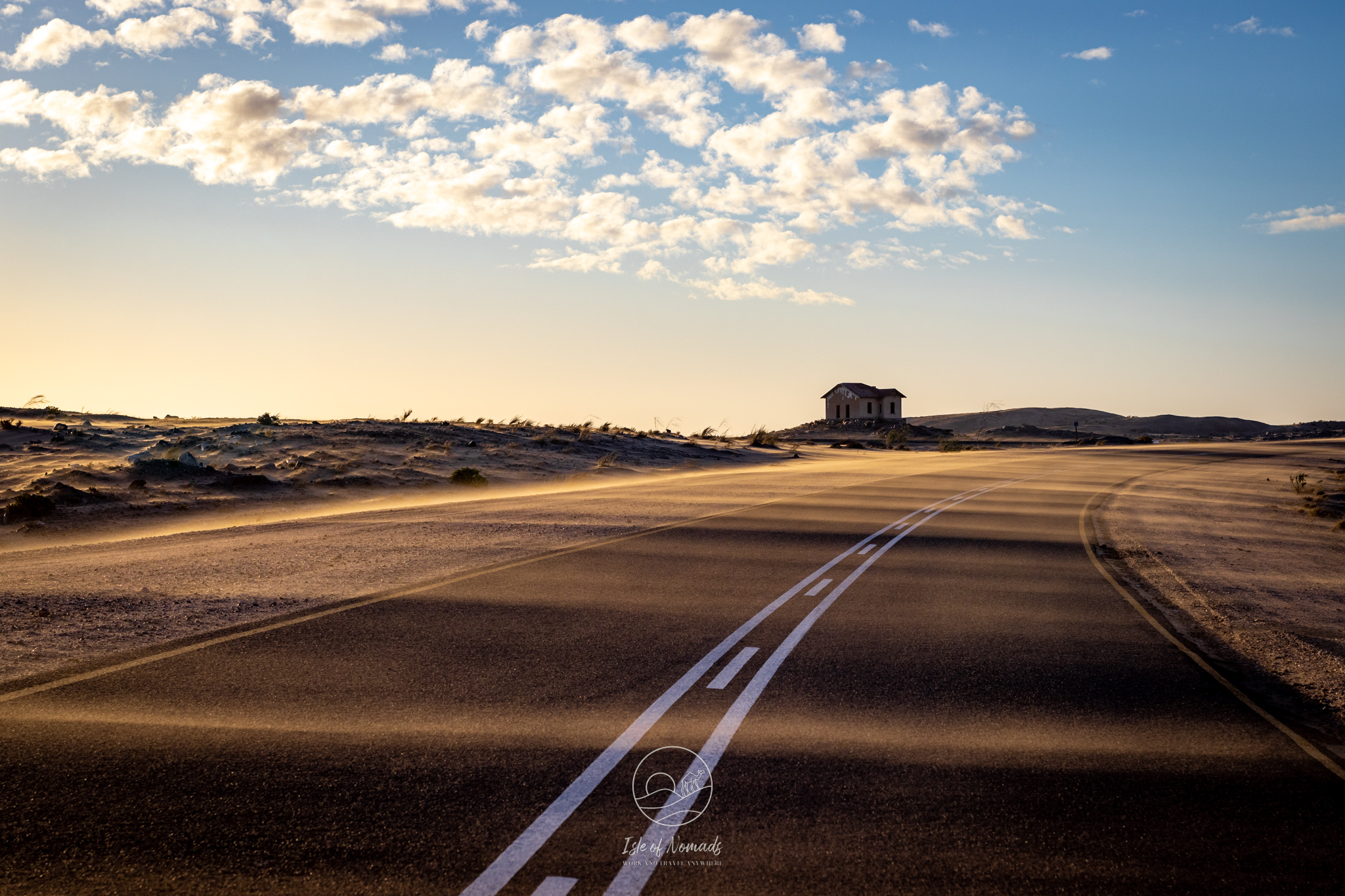 Beautiful evening light illuminiating the sand being blown across the road to Luderitz in Namibia